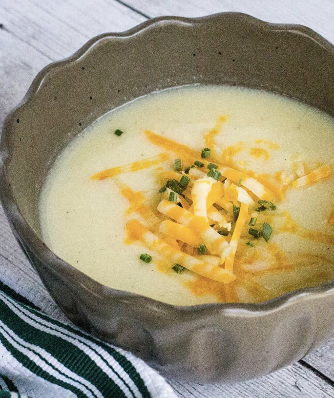 brown bowl filled with cheesy cauliflower soup cooked in the Instant Pot