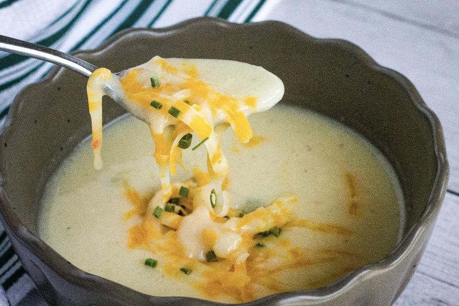 spoonful of cauliflower soup topped with melted cheese
