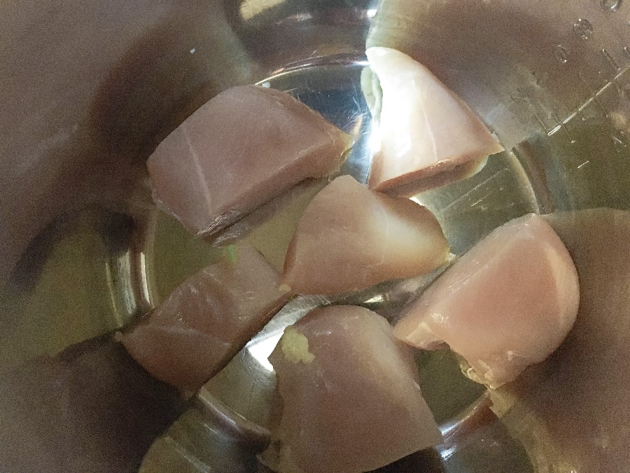 Boneless skinless chicken breast pieces in the insert pot of the Instant Pot