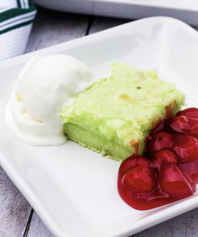 ooey gooey pistachio butter cake bar served with cherries and ice cream