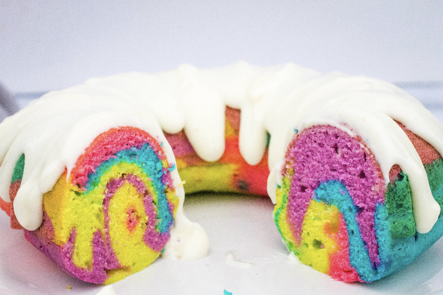 A rainbow bundt cake that was cooked in the pressure cooker, with two slices removed.