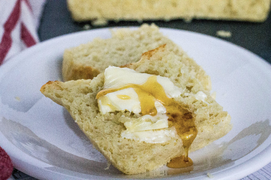 slice of Instant Pot no knead  English muffin bread topped with butter and honey