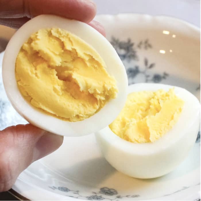 a hand holding hard boiled eggs that were cooked in the Instant Pot