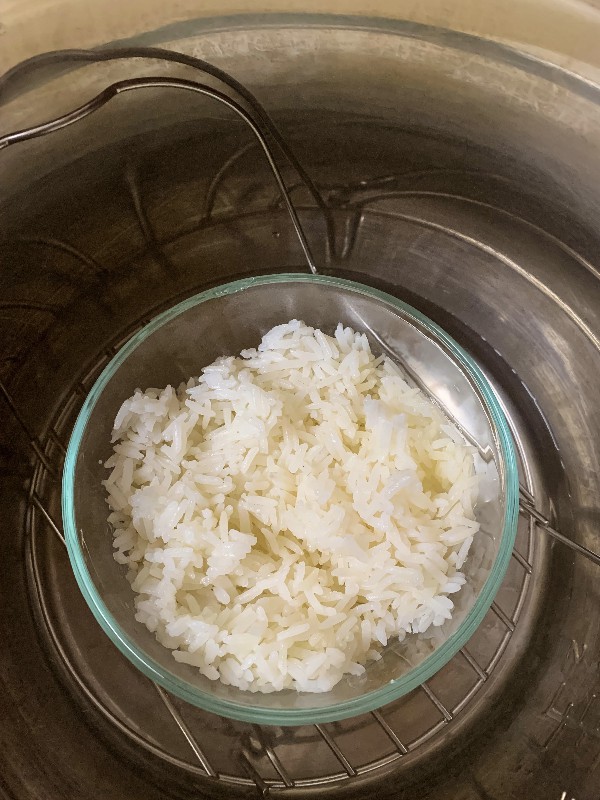 Glass Pyrex bowl of white rice inside the insert pot of an Instant Pot
