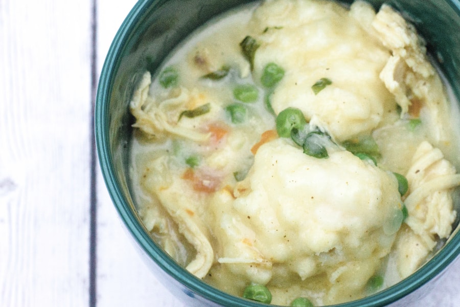 Green bowl filled with chicken and drop biscuit dumplings made with BIsquick