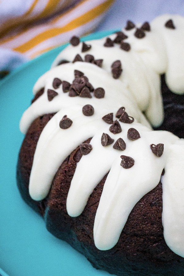 Instant Pot Chocolate bundt cake with cream cheese frosting on a turquoise plate