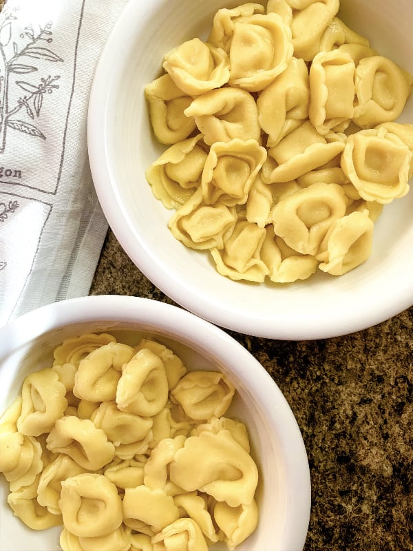 two white bowls filled with cheese tortellini that was cooked in the Instant Pot pressure cooker
