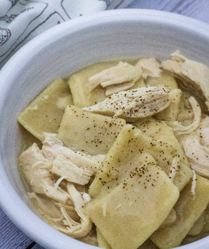White bowl filled with Instant Pot chicken and dumplings made with frozen dumplings