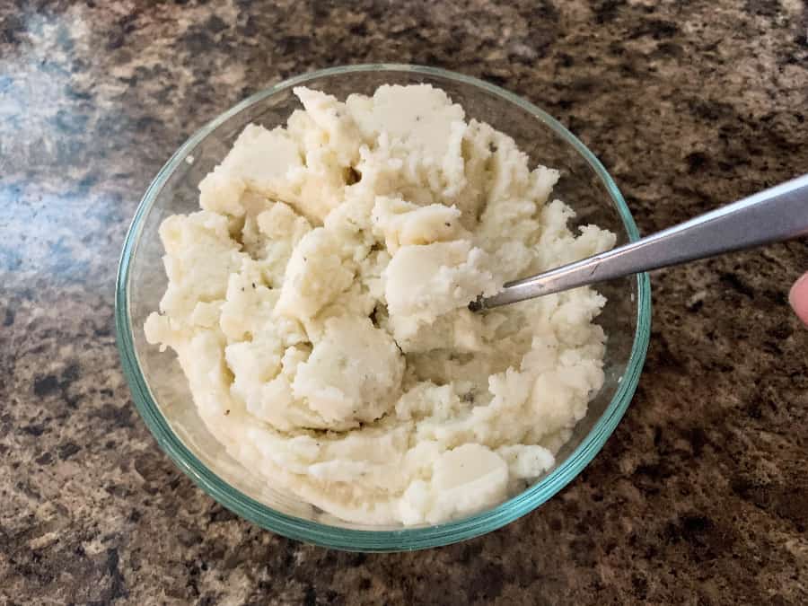 Mashed potatoes in a glass bowl, fluffed for reheating in the Instant Pot