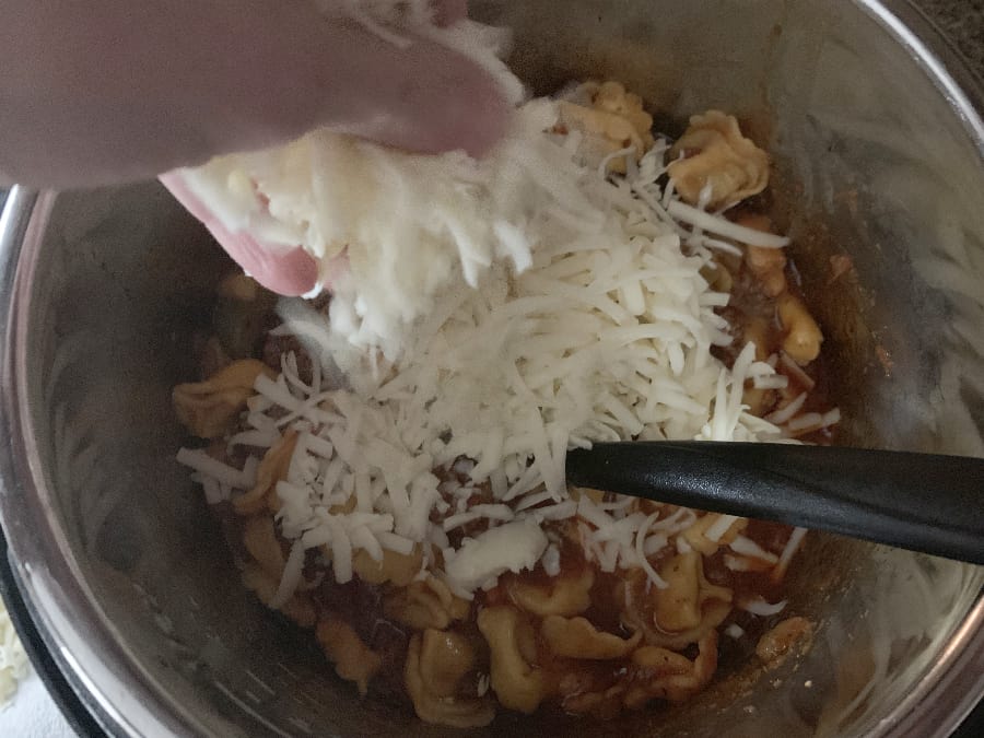 shredded mozzarella cheese on top of the pizza tortellini