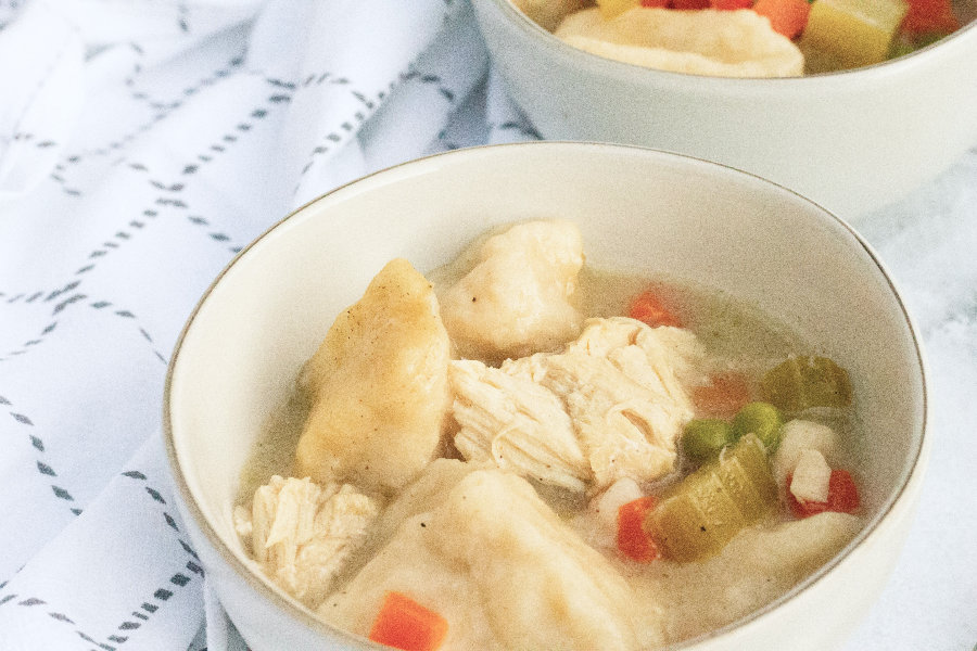 two white bowls of chicken and biscuit dumplings