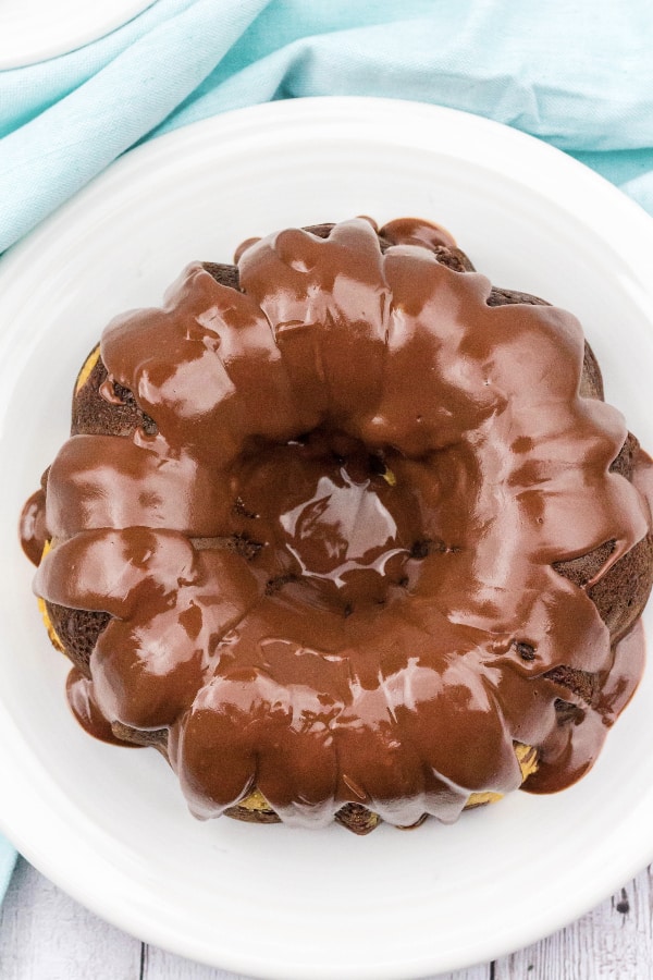 Peanut butter chocolate bundt cake topped with chocolate ganache on a white plate