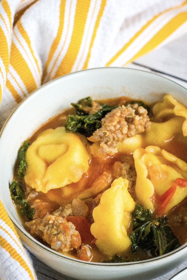 easy Instant Pot tortellini soup with sausage and kale in a white bowl
