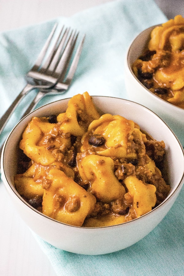 two white bowls of Mexican enchilada tortellini casserole cooked in the Instant Pot
