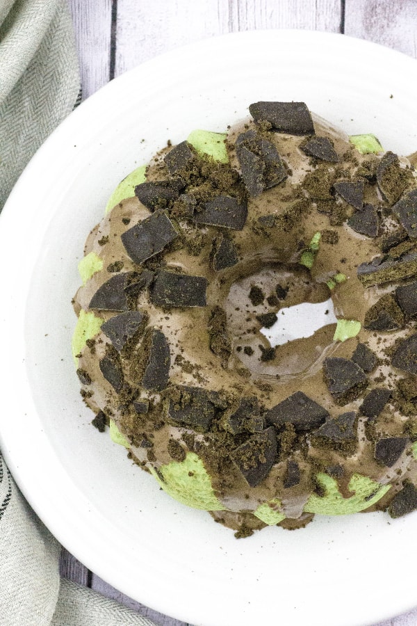 mint chocolate bundt cake on a white plate, topped with mint chocolate cookies