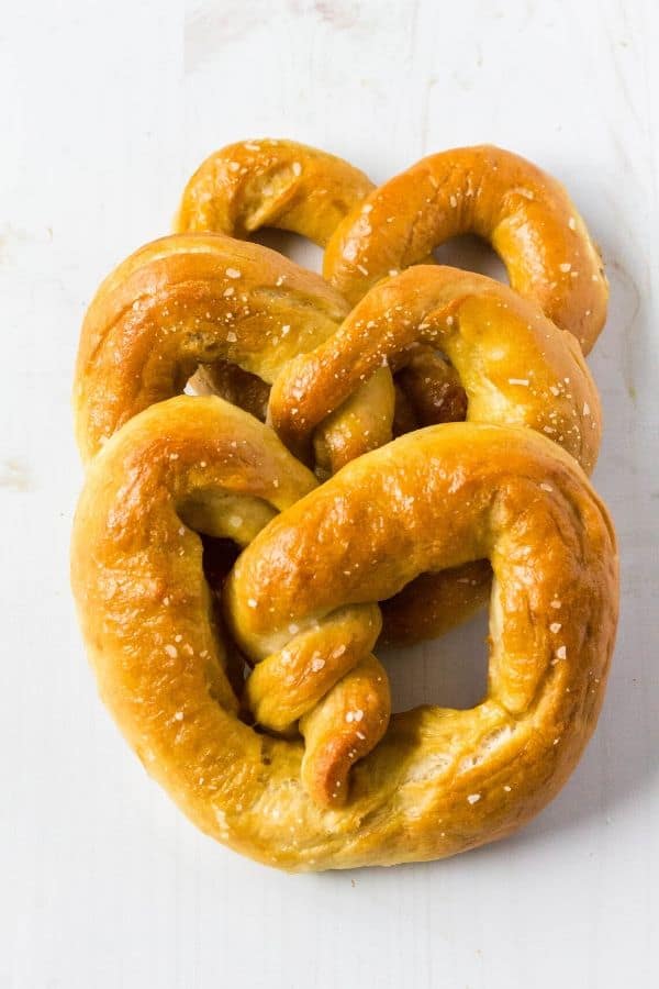three homemade soft pretzels stacked together in a row