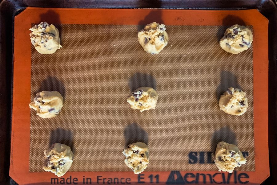 balls of chocolate chip cookie dough on a baking sheet