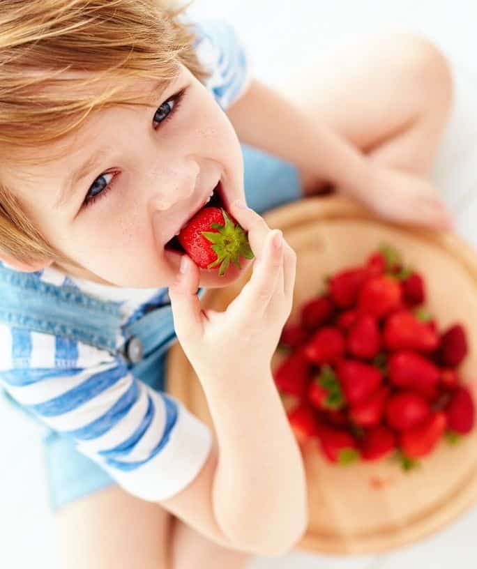 kid eating strawberries