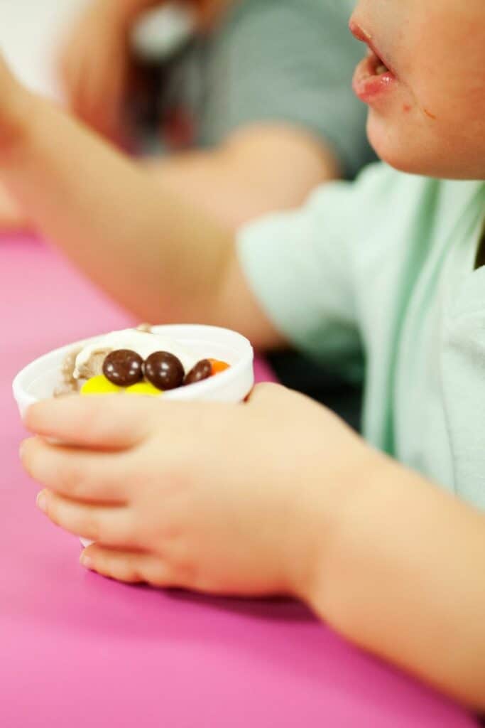 Young girl holding a cup of yogurt with berries