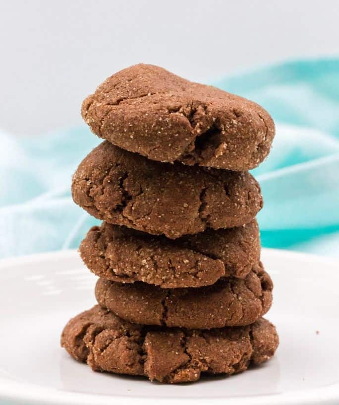 five chocolate snickerdoodles in a stack on a white plate