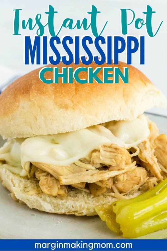 Mississippi chicken sandwich with cheese on a plate, with a pepperoncini next to it
