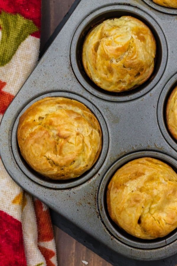 muffin tin with pumpkin cream cheese swirl muffins in it