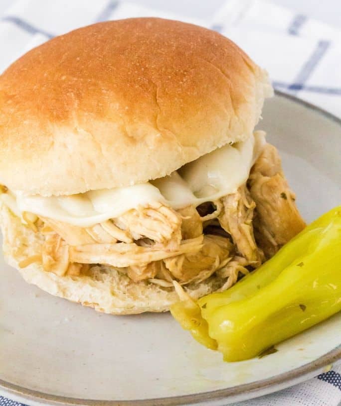 Mississippi chicken sandwich on a plate with a pepperoncini