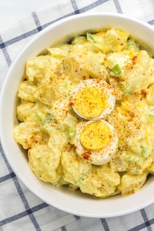 white serving bowl filled with potato salad that was cooked in the Instant Pot