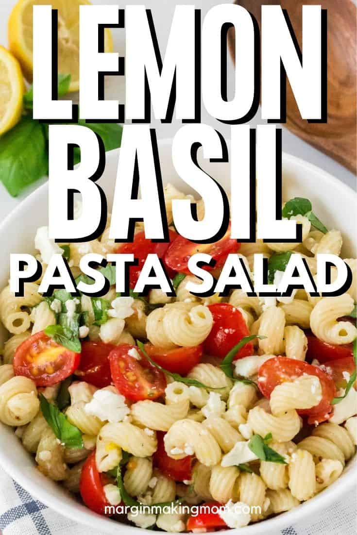 a white bowl of lemon basil pasta sald with tomatoes and feta cheese