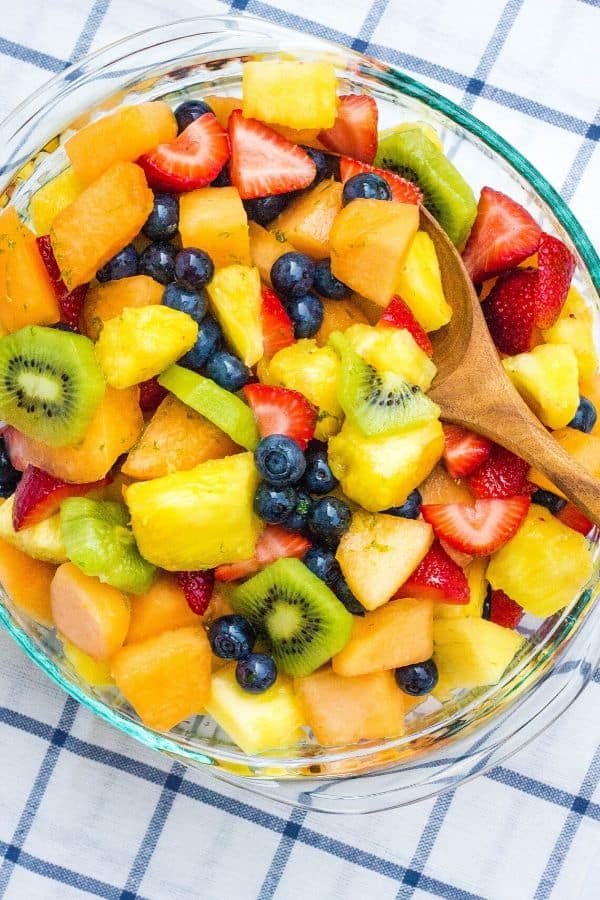 honey lime fruit salad dressing drizzled over pineapple, cantaloupe, strawberries, kiwi, and blueberries.