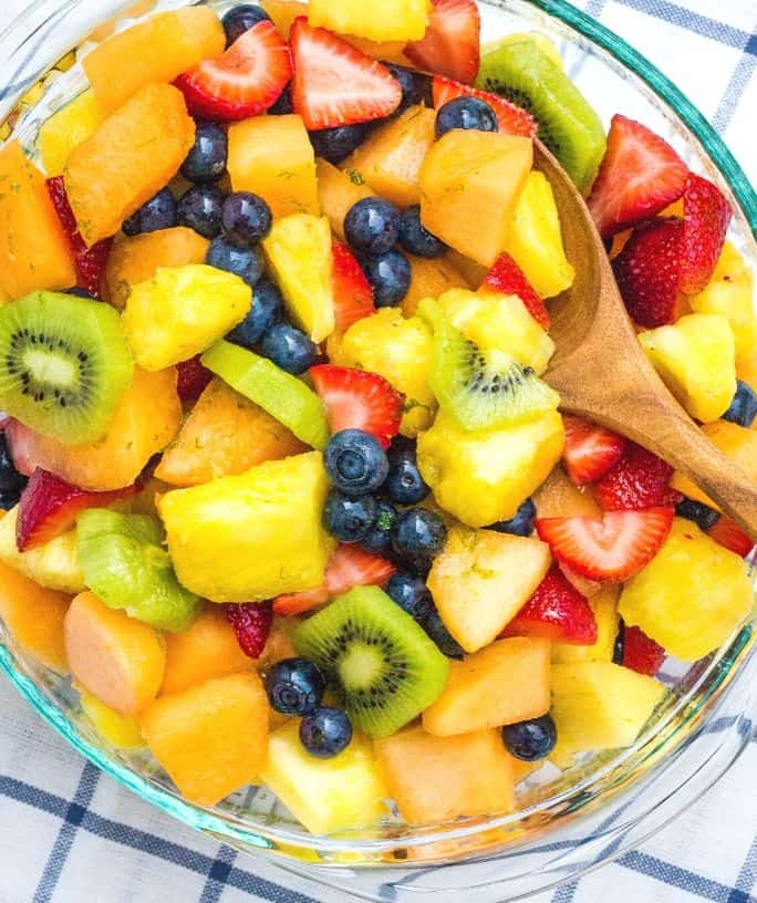 serving bowl filled with fruit salad mixed with honey lime dressing
