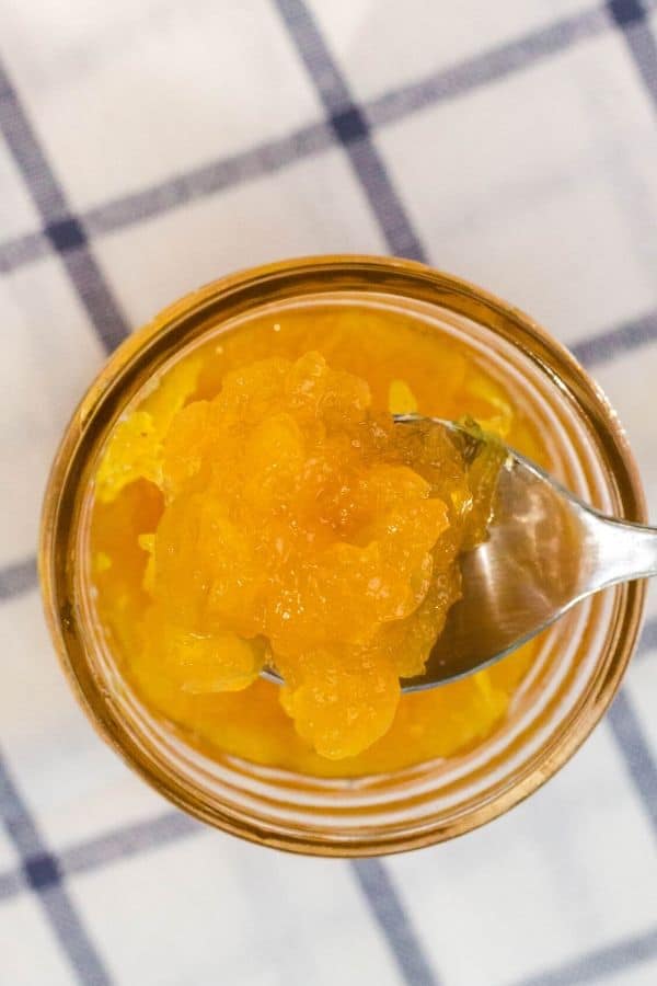 jar of pineapple jam with a spoon scooping some out