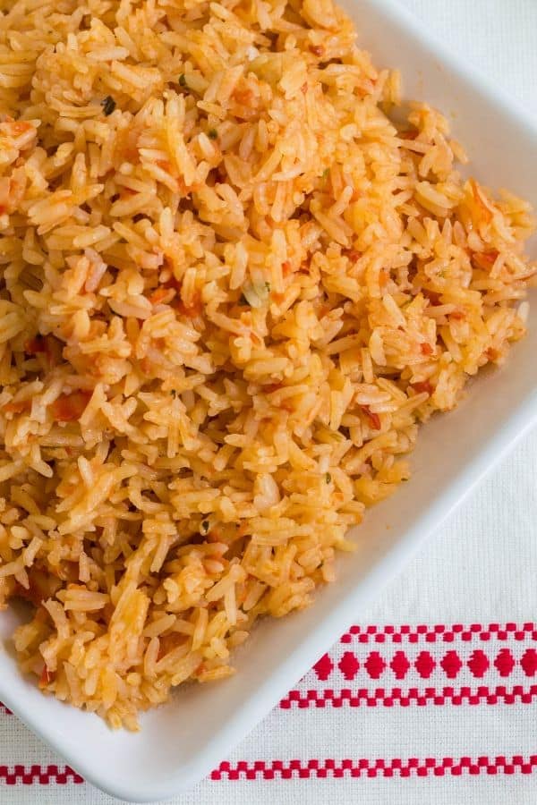 white plate of Mexican rice cooked in the Instant Pot, on a red and white napkin