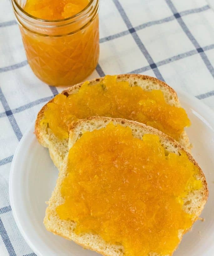 two slices of bread on a white plate, topped with homemade Instant Pot pineapple jam