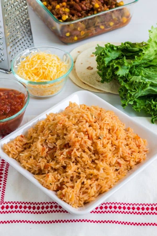 a spread of ingredients for a Mexican dinner, featuring Spanish rice cooked in the Instant Pot pressure cooker