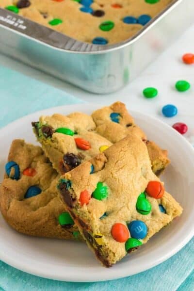 white plate with three M&M Cookie bars on it