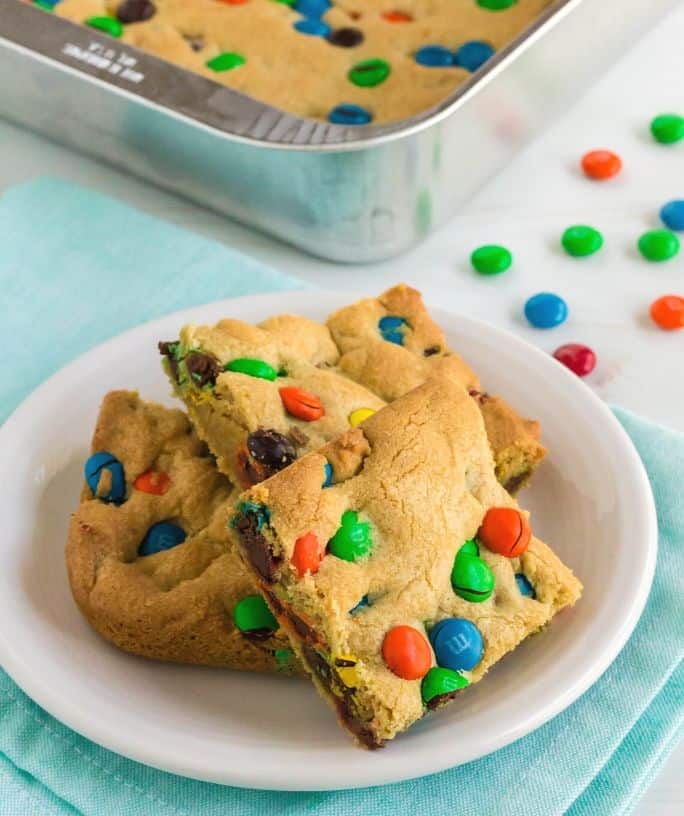 white plate with three M&M Cookie bars on it