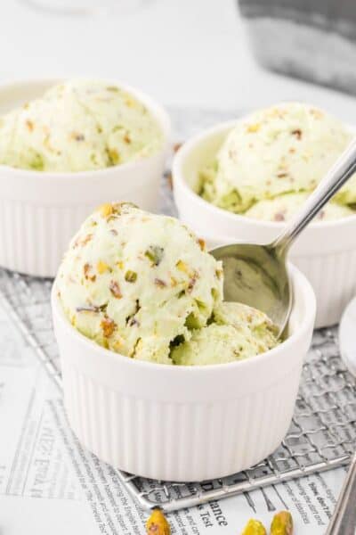 scoops of no churn pistachio ice cream served in white dessert cups