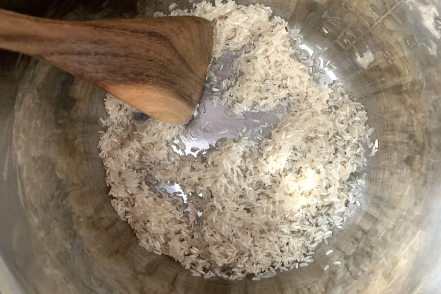 White rice being sauteed in oil in the Instant Pot