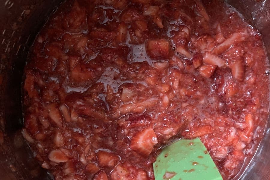 strawberries in the insert pot of the Instant Pot, macerated with sugar and lemon juice