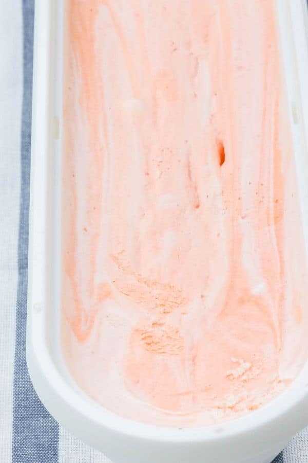 a full serving container of homeamde orange creamsicle ice cream