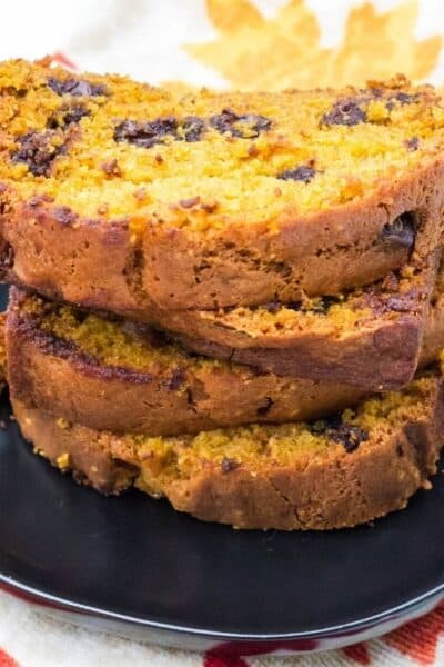 stacked slices of pumpkin chocolate chip bread on a black plate