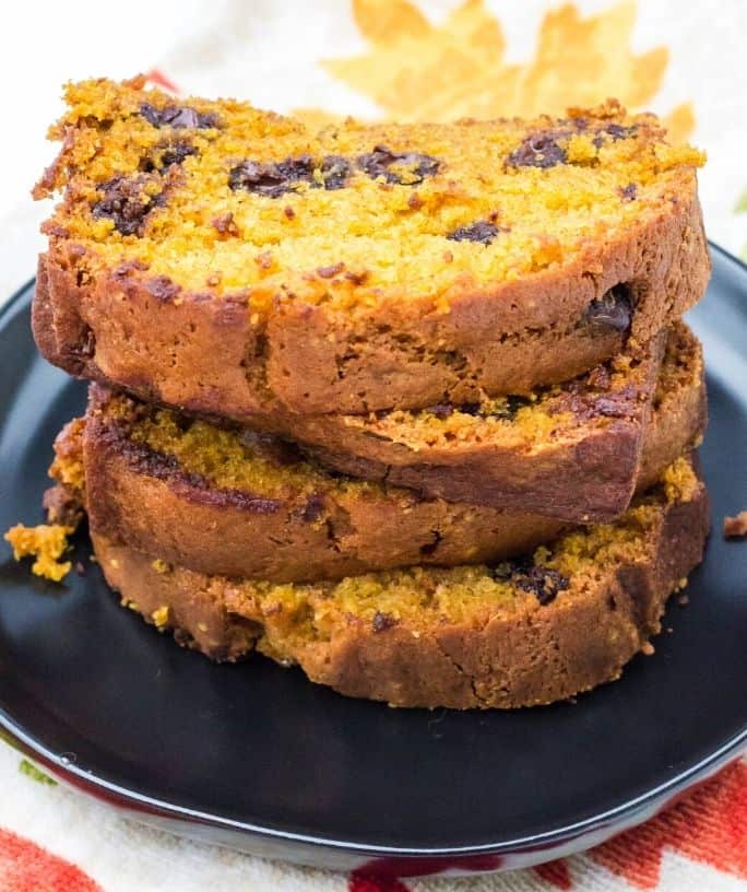 stacked slices of pumpkin chocolate chip bread on a black plate