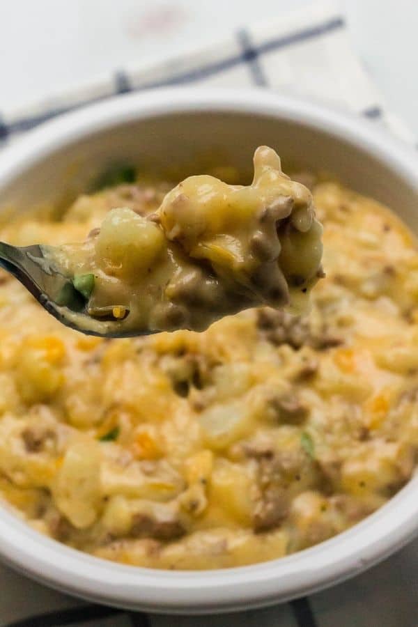 A fork lifting out a bite of cheesy Instant Pot ground beef and potatoes