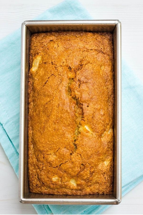freshly baked loaf of pear bread with no streusel on top, still in the pan