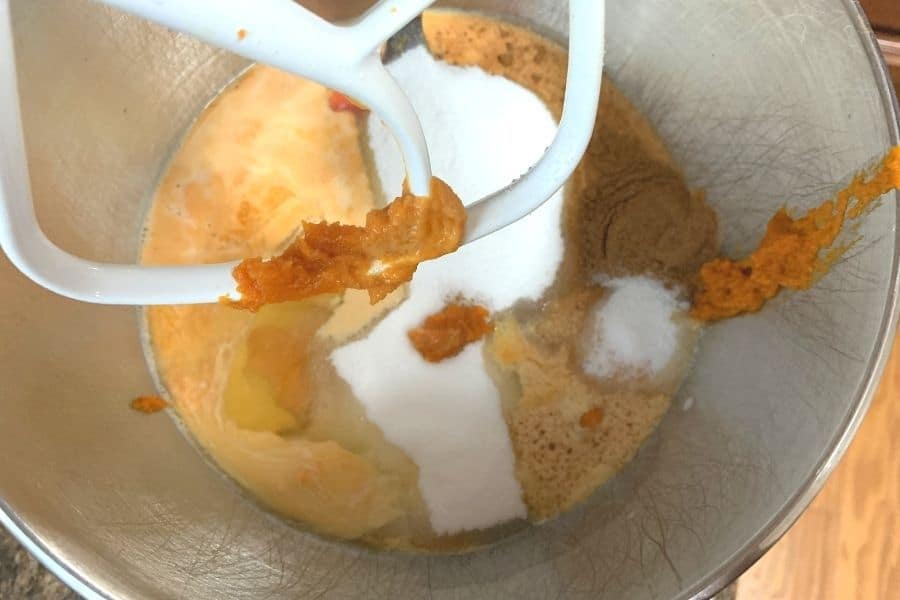 pumpkin puree, evaporated milk, eggs, sugar, pumpkin pie spice, and salt in the bowl of a stand mixer for preparing pumpkin crunch cake