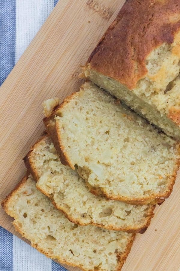 loaf of banana pear bread on a cutting board, with several slices cut