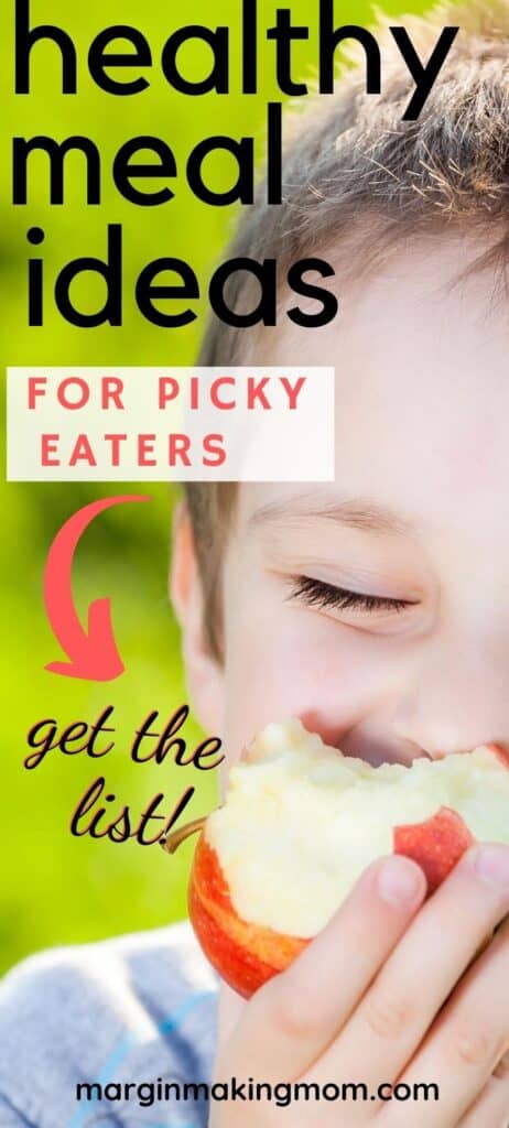 a young boy happily eating an apple