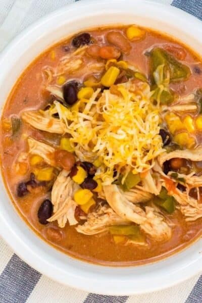 white bowl filled with Instant Pot chicken taco soup topped with shredded cheese