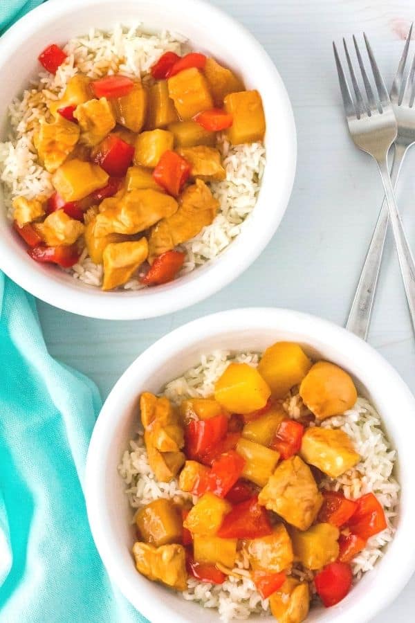 Instant Pot Hawaiian chicken and rice bowls next to two forks and a blue napkin